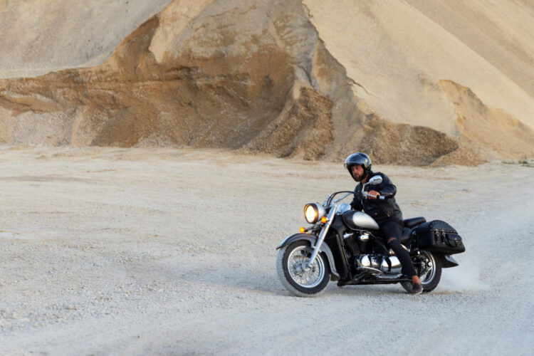 Visiškai nufotografuotas vyras važiuojantis motociklu