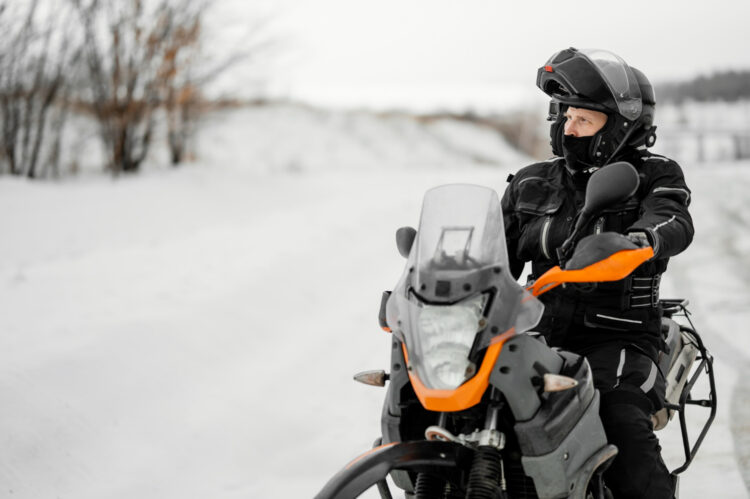 Vyras važiuojantis motociklu žiemos dieną