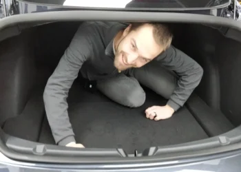 vyras automobilio bagazineje