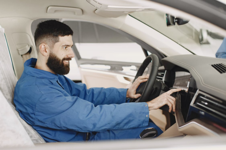 vyras sedi automobilyje