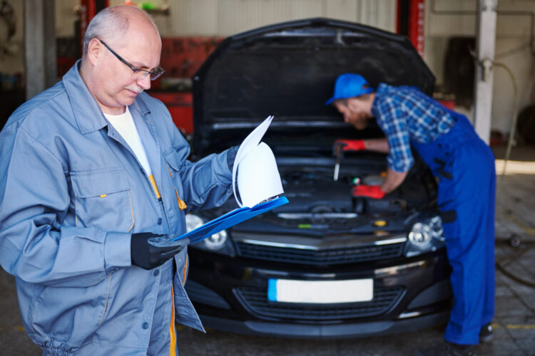 Mechanikai remontuojantys automobilį dirbtuvėse