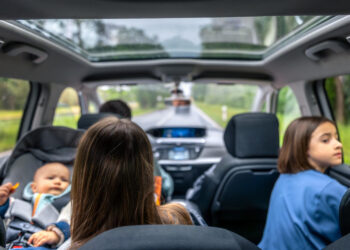Šeimos kelionė su kūdikiu automobilyje vaizdas į miško kelią keleiviai