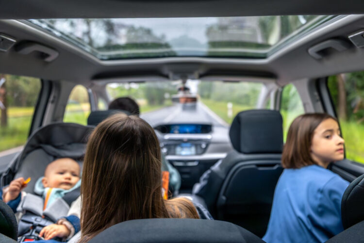 Šeimos kelionė su kūdikiu automobilyje vaizdas į miško kelią keleiviai