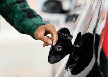 Vyras degalinėje su automobiliu