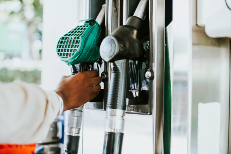 Vyras paėmęs degalų pistoletą kad papildytų savo automobilį