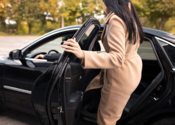Moteris įsėda į taksi automobilį