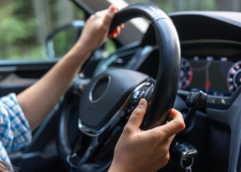 Rankos ant šiuolaikinio automobilio vairo važiuojant vairavimo kontrolė ir pasitikėjimas kelyje