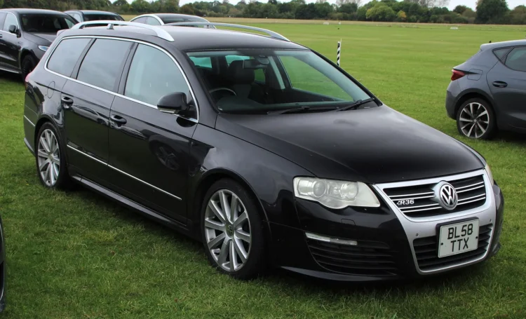 Brangaus „Passat R36“ ieškantiems pirkėjams – du modeliai, kurių variklis lygiai toks pat 1 Juodas Volkswagen Passat R36 universalas iš priekio ir šono, stovintis ant žolės