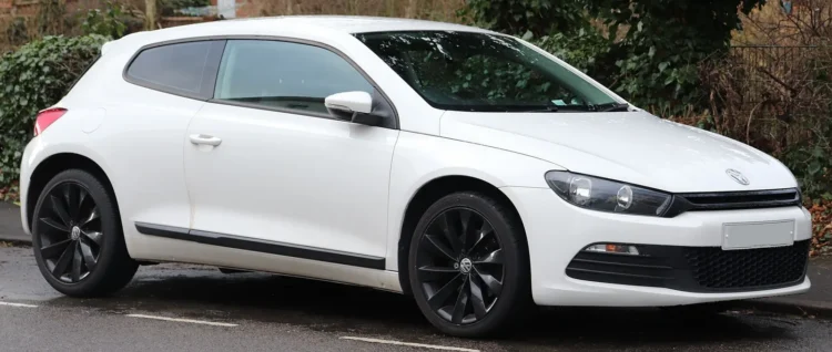 Senesniu 1,4 litro turbininiu varikliu važinėjantiems vairuotojams gresia gedimas, kurį išgirsite užvedus 1 1.4 TSI EA111 varikliu varomas baltas 2010 m. Volkswagen Scirocco iš priekio ir šono gatvėje
