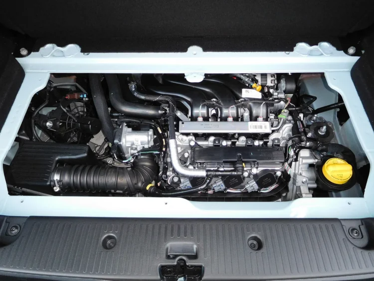 Naudoto miesto automobilio pirkėjams – mažas trijų cilindrų variklis mieste sunaudoja iki 7,2 l/100 km, bet po 100 000 km reikalauja vieno darbo 1 1.0 SCe variklis Renault Twingo III variklio skyriuje: trijų cilindrų agregatas su geltonu alyvos dangteliu