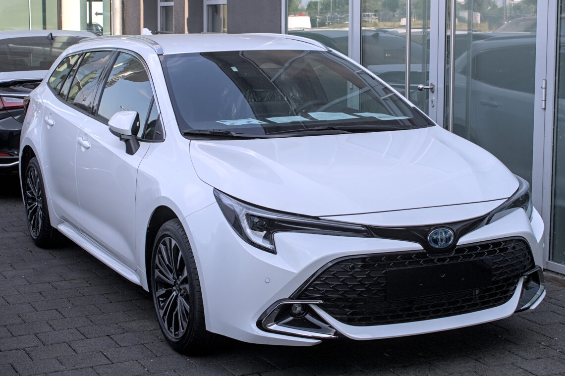 2023 Balta atnaujinta Toyota Corolla Touring Sports hibridinis universalas iš priekio ir šono