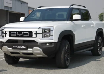 Baltas BYD Shark 6 hibridinis pikapas su dviguba kabina iš priekio ir šono, stovintis aikštelėje