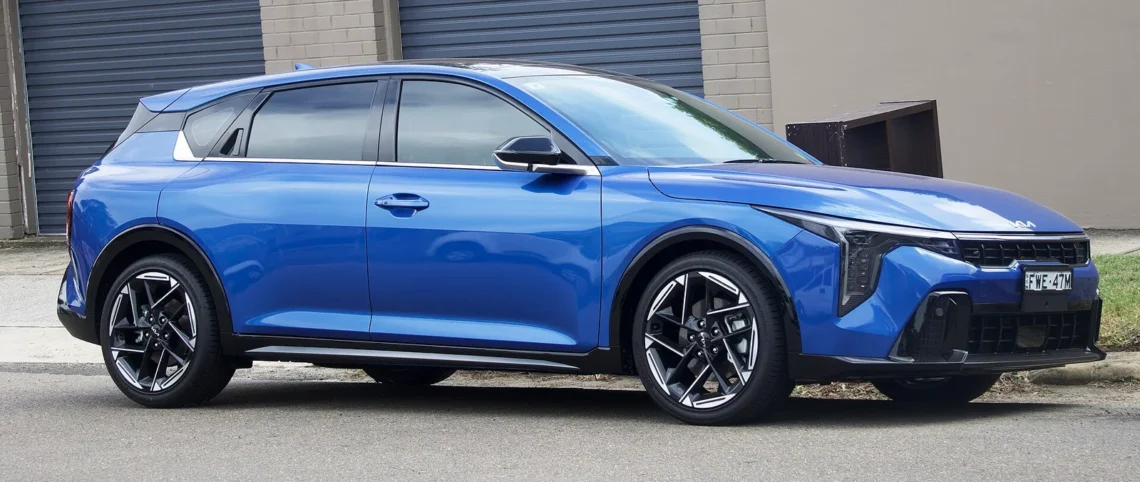 Naujo korėjietiško kompakto pigesnės versijos geriau nepirkti – testuotojas įvardijo, kurią rinktis 1 Kia K4 universalas: kia K4 universalo giminaitis: mėlynas Kia K4 GT-Line hečbekas iš šono ir priekio gatvėje