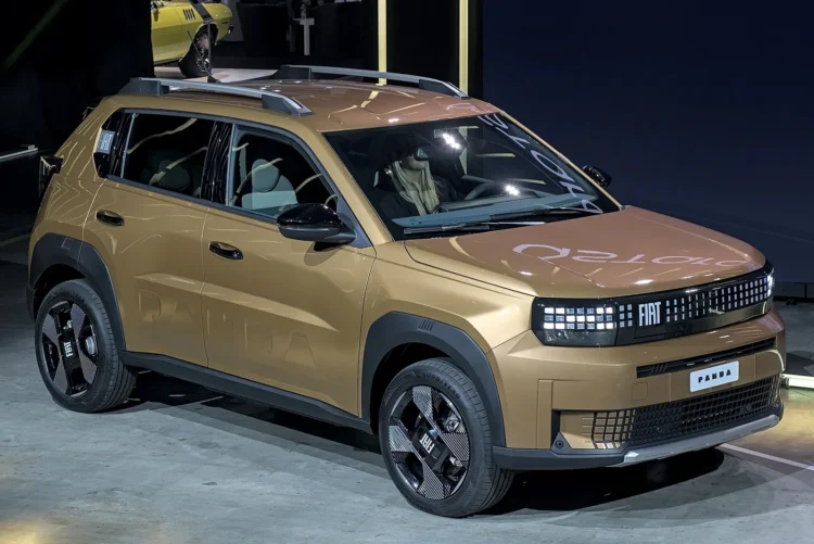 Itališko elektromobilio vairuotojai galės nuvažiuoti iki 400 km – visoms elektrinėms versijoms teks vienas kompromisas 1 Fiat Grande Panda 54 kWh – elektrinis bronzinės spalvos miesto visureigis iš priekio ir šono parodoje