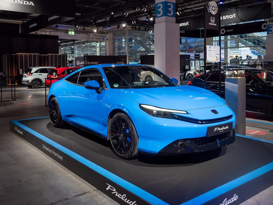 Atgimusio japoniško kupė už 49 900 eurų geriau nepirkti tiems, kam svarbi bagažinė 1 Honda Prelude testas: mėlynas naujosios kartos Honda Prelude kupė parodos stende iš priekio ir šono