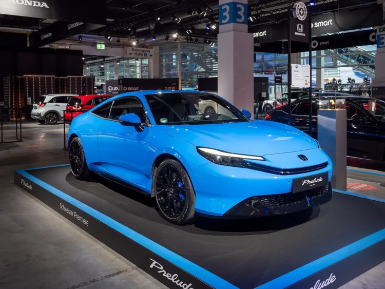 Atgimusio japoniško kupė už 49 900 eurų geriau nepirkti tiems, kam svarbi bagažinė 1 Honda Prelude testas: mėlynas naujosios kartos Honda Prelude kupė parodos stende iš priekio ir šono