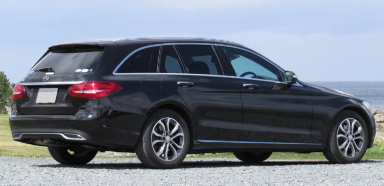 Mercedes C 250 d pirmtakas: juodas Mercedes-Benz C klasės S205 universalas iš galo ir šono prie jūros