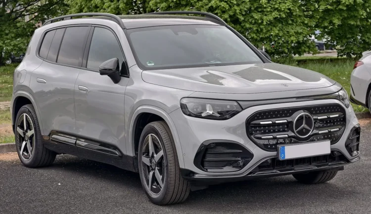 Elektrinis Mercedes GLB: naujos kartos pilkas visureigis su AMG Line apdaila stovi aikštelėje