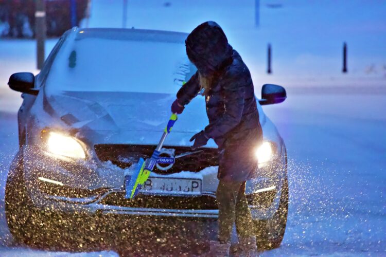 moteris ziema valo automobili nuo sniego