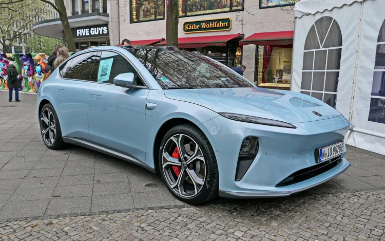 Kiniškų automobilių testai: šviesiai mėlynas Nio ET5 elektrinis sedanas, pastatytas miesto gatvėje
