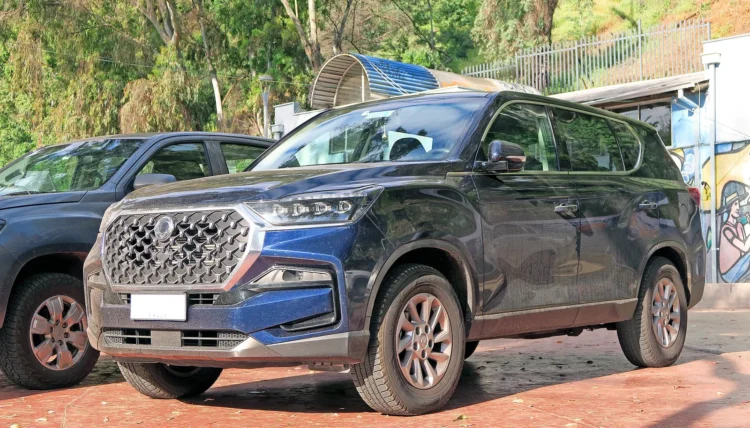 Penkios savybės, kurių daugumoje šeimos visureigių nebeliko – korėjietiškas modelis jas išsaugojo 1 Tamsiai mėlynas KGM (SsangYong) Rexton visureigis iš priekio ir šono, stovintis aikštelėje