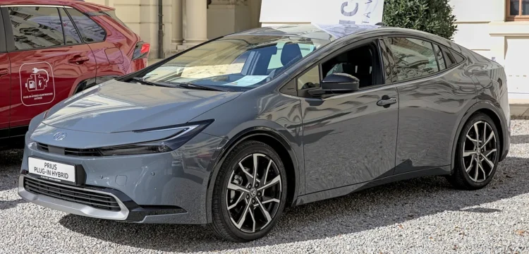 Ieškantiems taupaus hibrido – penki sedanai, kurie sunaudoja mažiau nei populiarus krosoveris 1 Hibridiniai sedanai: pilka naujos kartos Toyota Prius plug-in hybrid iš priekio ir šono ant žvyro aikštelės
